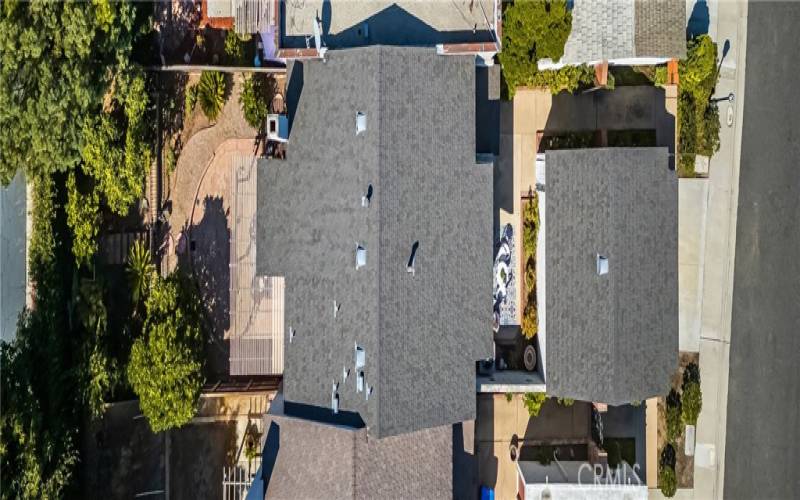 Aerial view of the spacious lot with a well-maintained roof and mature landscaping