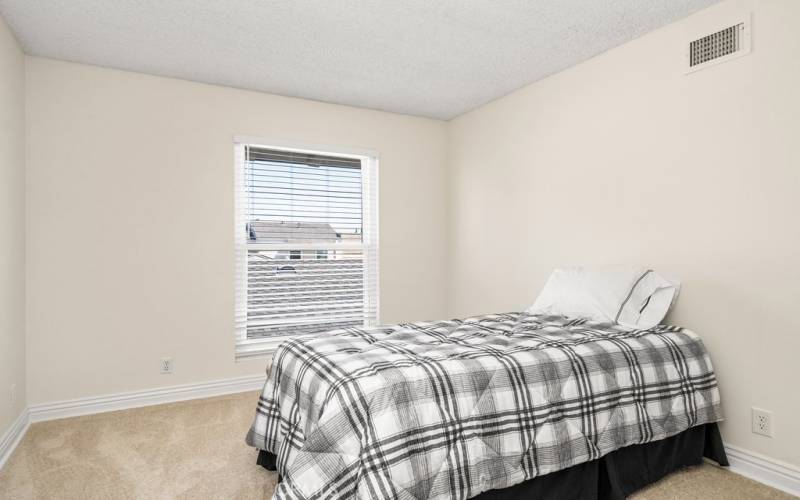 Bright and airy bedroom 3 with hardwood floors and ample natural light