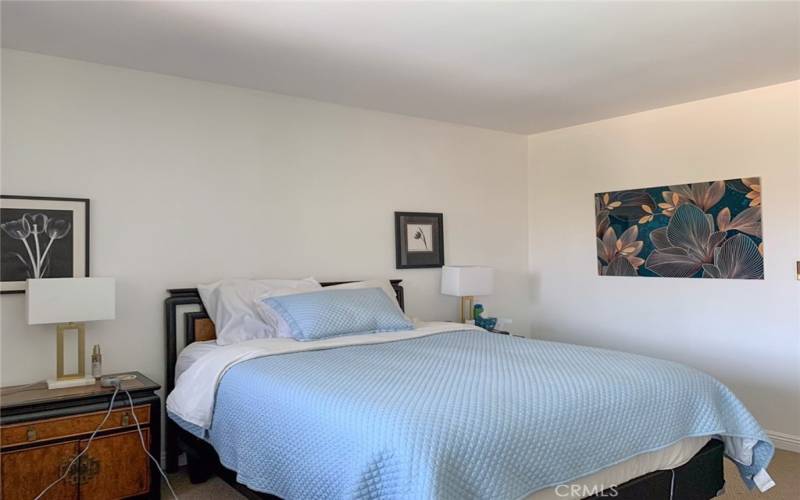 Primary bedroom is very spacious, with mirrored closet doors: bedroom furniture and artwork included in lease