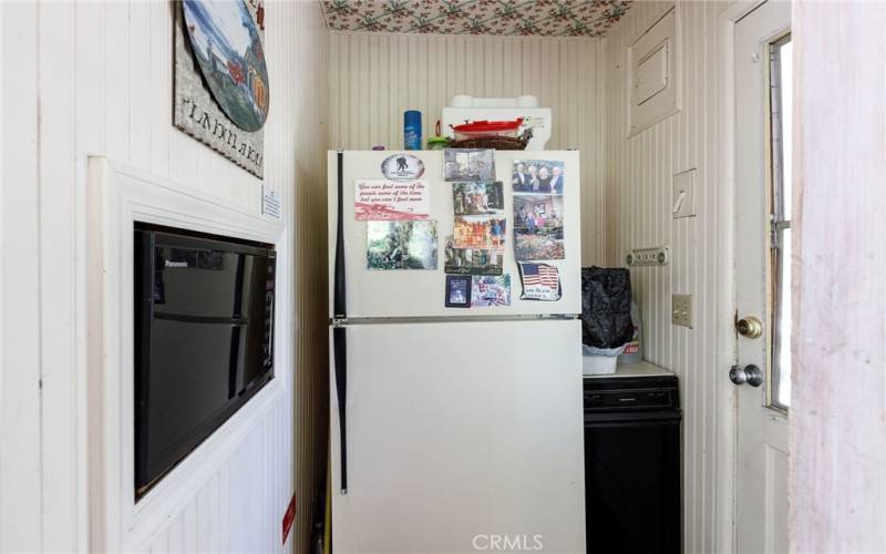 Kitchen extension with built-in microwave and refrigerator and side door.