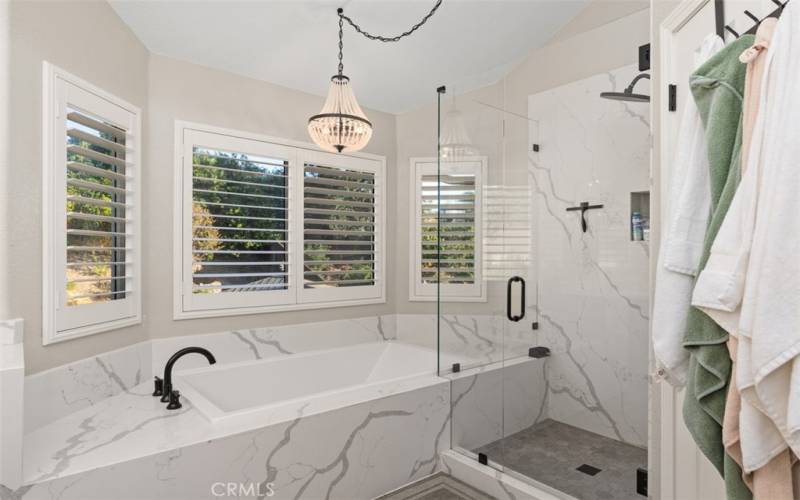 Custom Shower With Two Shower Heads And A Separate Soaking Tub In The Primary Bathroom