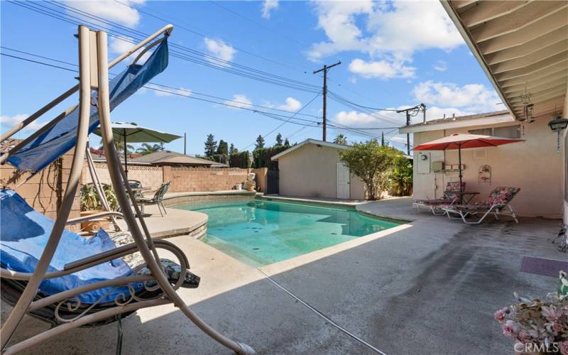 Private backyard with patio and sparkling pool.