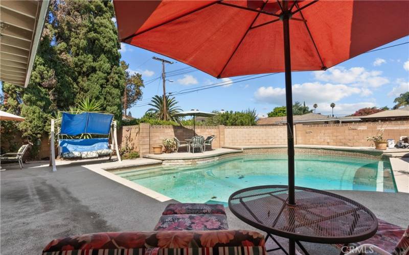 Private backyard with patio and sparkling pool.