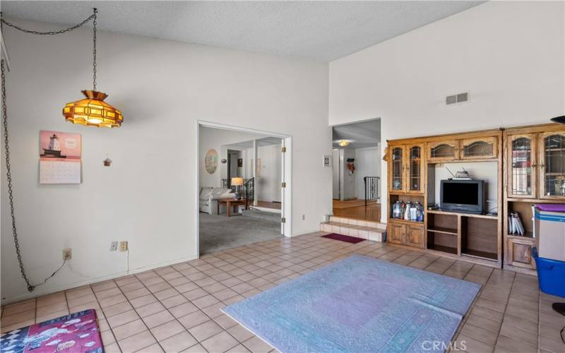 Step down Family Room with vaulted ceilings and sliding door to the backyard patio and sparkling pool.