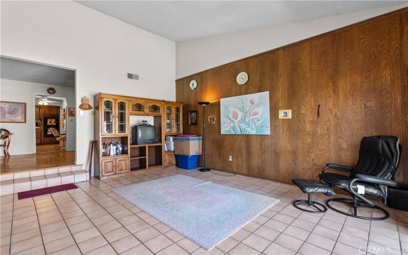 Step down Family Room with vaulted ceilings and sliding door to the backyard patio and sparkling pool.