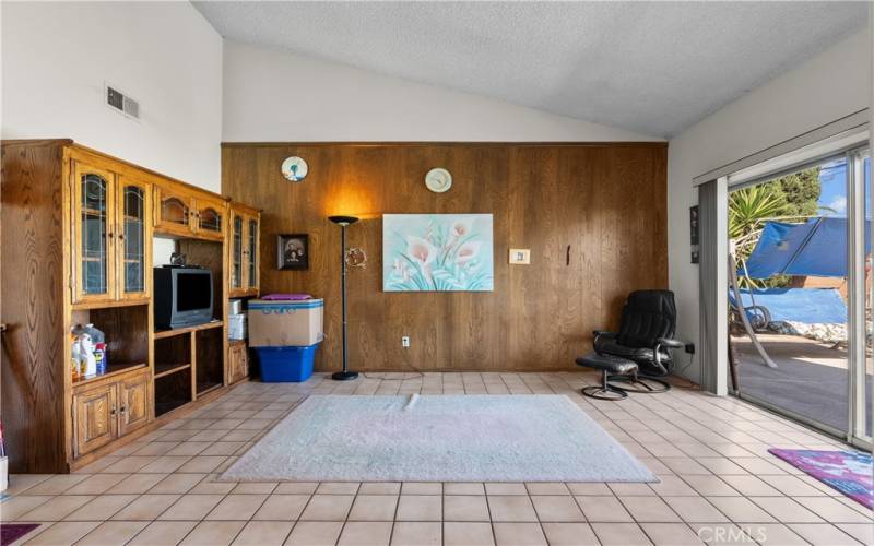 Step down Family Room with vaulted ceilings and sliding door to the backyard patio and sparkling pool.