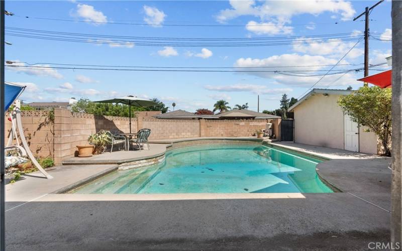 Private backyard with patio and sparkling pool.