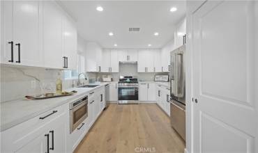 Gorgeous, spacious kitchen with ample cabinets, top of the line  appliances, high end porcelain counter top, recessed lighting and engineered wood flooring.