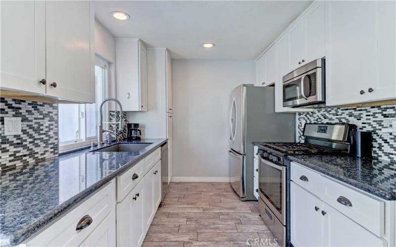 Remodeled kitchen with updated cabinets, granite counters, tile backsplash and stainless steel appliances