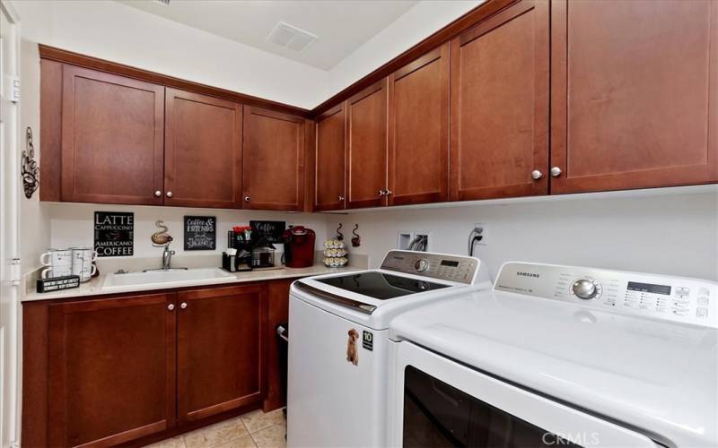 LAUNDRY ROOM HAS LOTS OF STORAGE AND UTILITY SINK