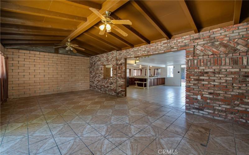 The living room is built with bricks and a beautiful wood beamed ceiling.