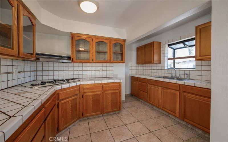 The kitchen has many cabinets for a lot of storage, a stovetop, a bay window and a NEW sink and NEW fixture.