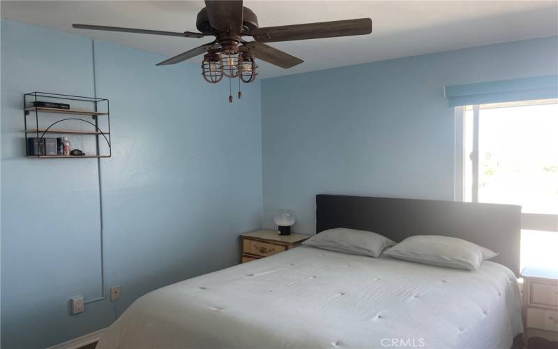 Large bedroom with ceiling fan and natural light