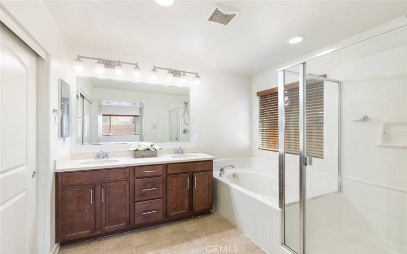 
This spacious bathroom features a glass-enclosed shower, a relaxing soaking tub, and a dual-sink vanity, offering both style and functionality.