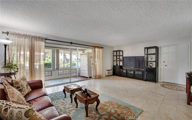 Large size living room, showing sliding doors to the enclosed patio. Great extra space for entreating, or just relaxing .