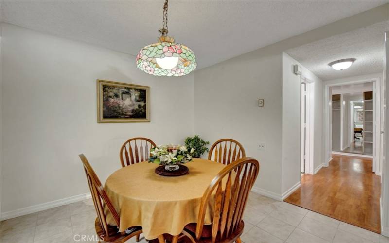 Dining area, showing Hall way to the Laminate look wood flooring with a large sliding mirror wardrobe at end with shelves.