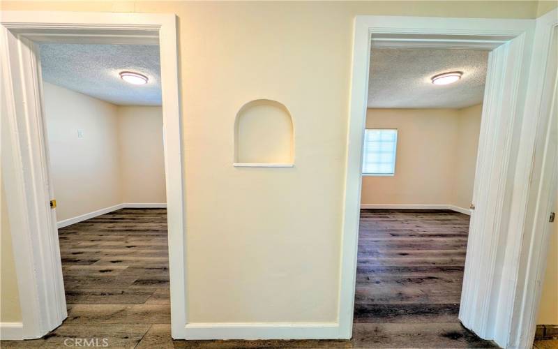 Hallway access from the Living Room, View of Bedroom 2(left) and 1 (Right) with accent piece  in center.