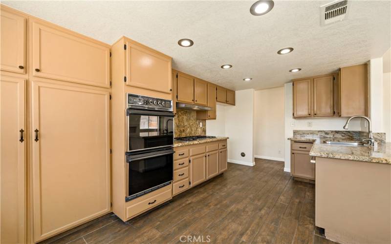 Reverse angle of kitchen w dual ovens and range cook top