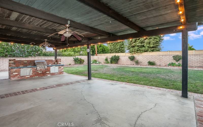 The beautiful private backyard will be a favorite entertainment destination with its green lawn, colorful raised flowerbeds, mature shade trees, expansive covered patio with lighted ceiling fans, and a built-in brick BBQ island with sink and tile countertops.