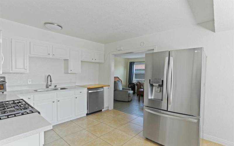 Kitchen looking into living room. large refrigerator.