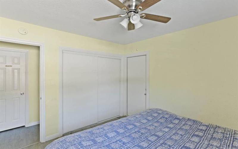 Bedroom with tracked door closet and access door to back yard patio.