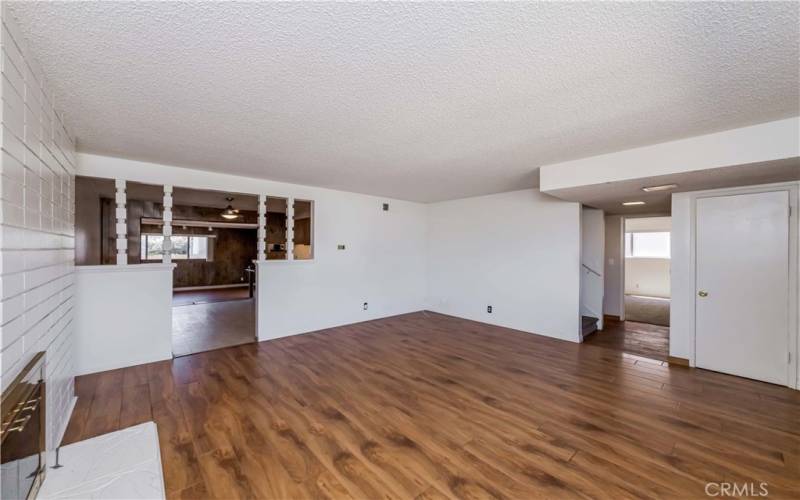 living room view with adjacent dining area and stairs and lower hallway to lower bedrooms