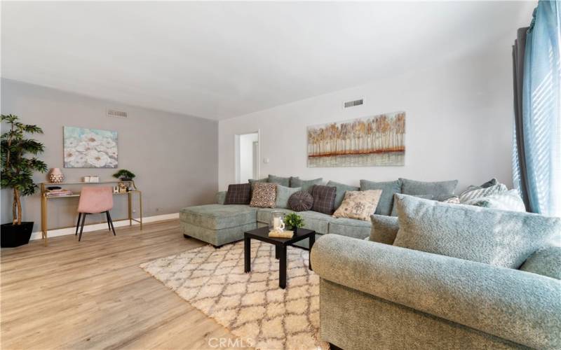 Lovely and spacious living room. Hallway to bedrooms in the distance throughway. Angle from the entry.