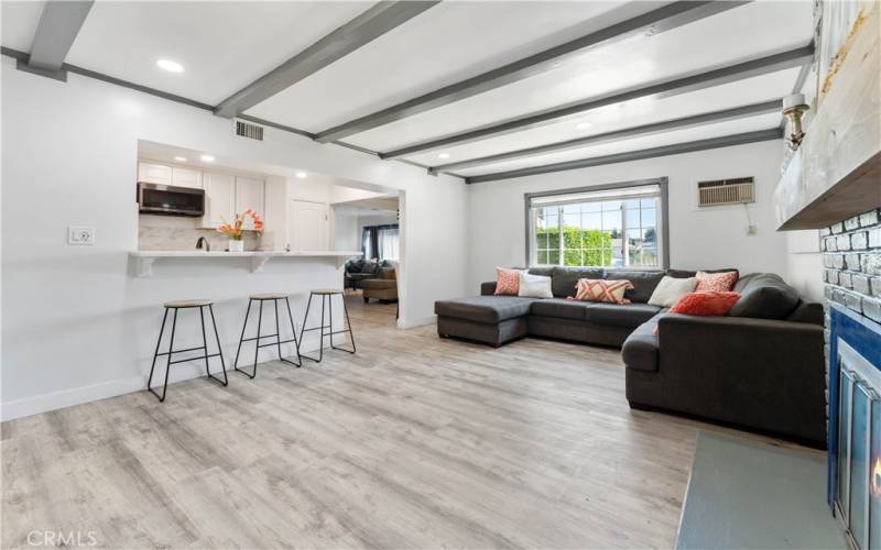 Roomy family room with brick fireplace and recessed lighting. Window in distance faces the front yard.