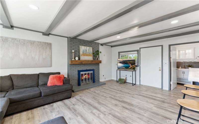 Family room with brick fireplace and exterior door to the backyard.