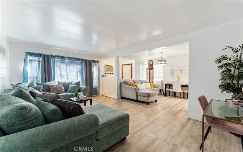 Standing from throughway to hallway looking onto the formal living room. Entry has a halfway that oversees the dining room/kitchen area (kitchen not seen)