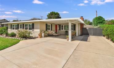 Front of House with gated backyard with pool, room for extra cars, toys and a 2 car garage!