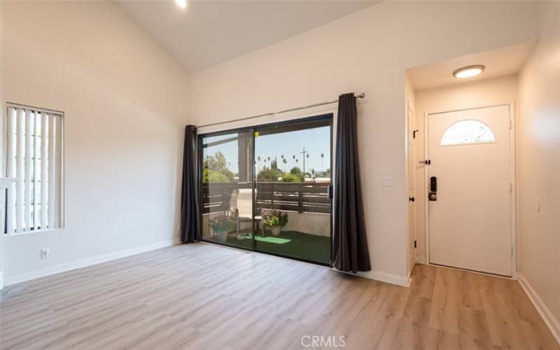 Entry with vaulted ceilings, new wood-style floors & deck off of living area