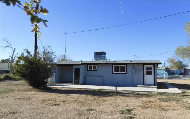 Back of home.  Covered utility area for washer/dryer to the left.  Also has water heater closet by utility area.