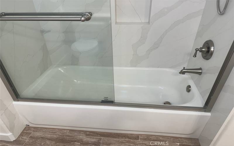 New tub shower in hall bathroom with quartz