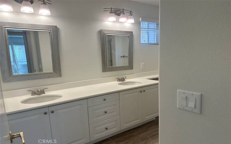 Hall bathroom by bedrooms with dual sinks.