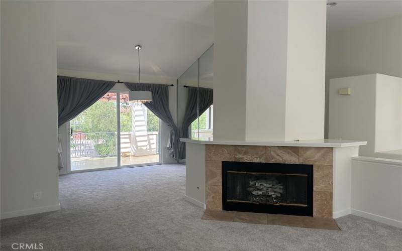 Living room with fireplace and decorative glass and logs ready for a cozy fall fire.