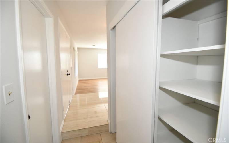 View of downstairs hallway from bath.  Coat closet and storage on righ.  Door to garage on left