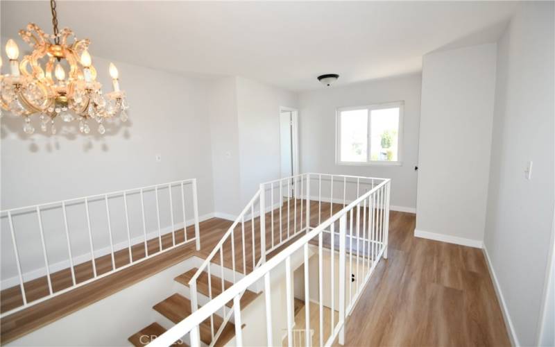 View of stairs and landing from 3rd bedroom doorway.