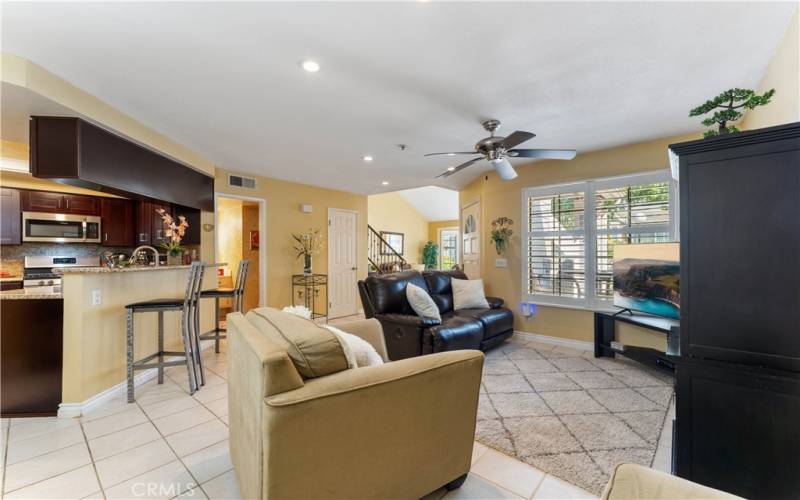 Standing from dining area overlooking the family and kitchen. Living room in the distance. Closet door is shut near the stairs. Doorway open near the updated kitchen is the lower level powder room.