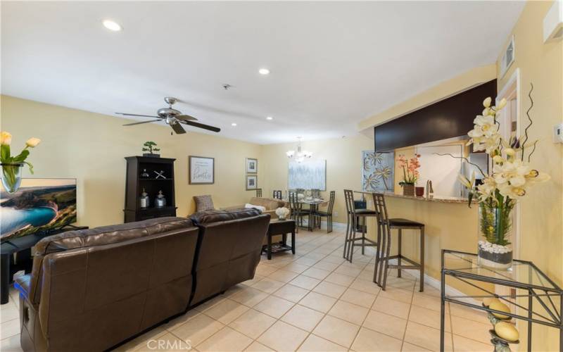 Family room with powder room beyond the credenza. Area to casually dine at updated kitchen bar and dining space towards the back.