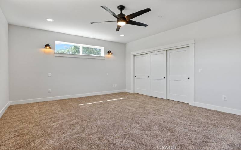 Master bedroom with sconce lighting and deep closet.