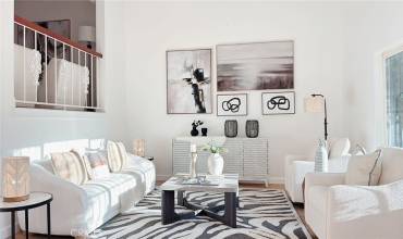 Living room with high ceilings. A large window in the front provides abundant natural light!