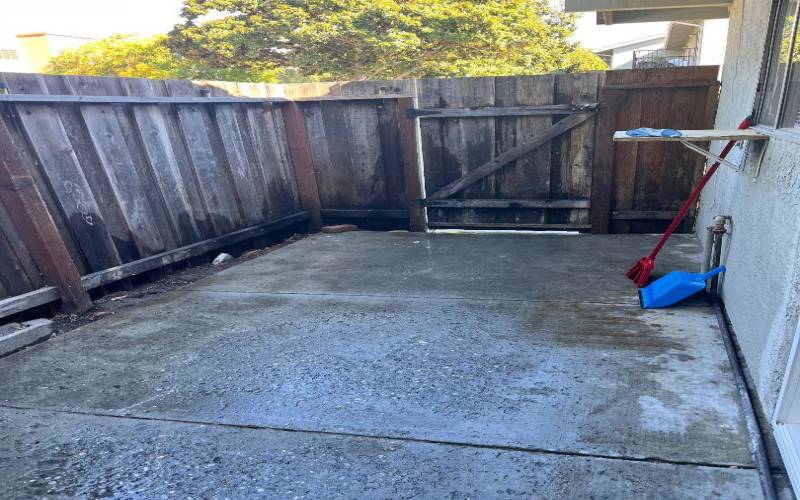 Enclosed patio with gate leading to carport