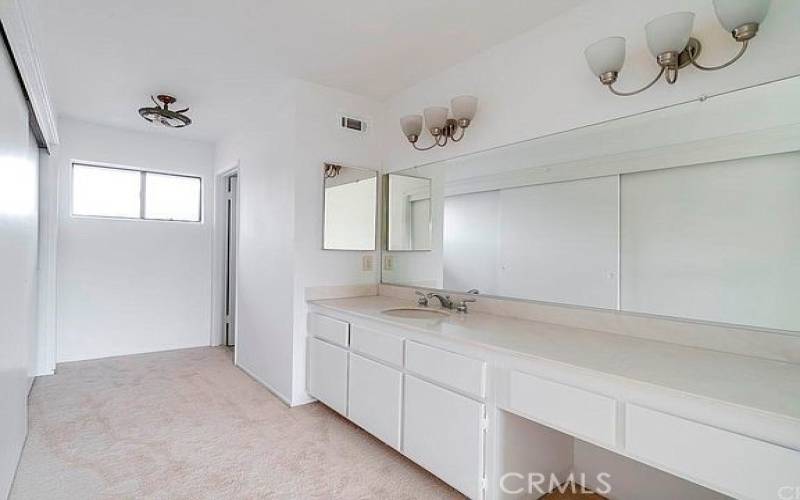 Huge vanity and sink with closet behind in Primary Bedroom.