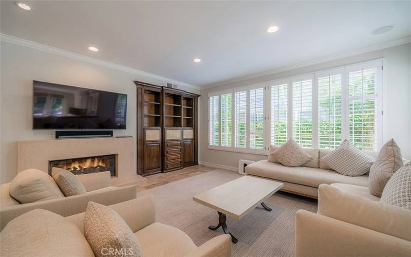 Family room with entertainment area, plantation shutters and built-in bookcase