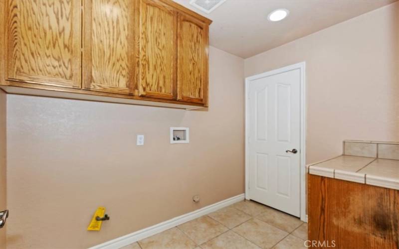 The laundry room also has a linen closet, cabinets and counter space.