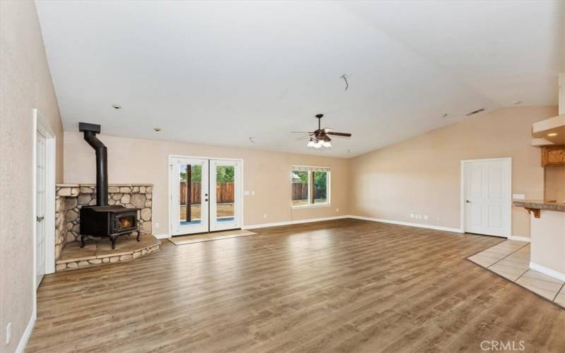 This great room has the freestanding fireplace and double doors to the covered patio in back.