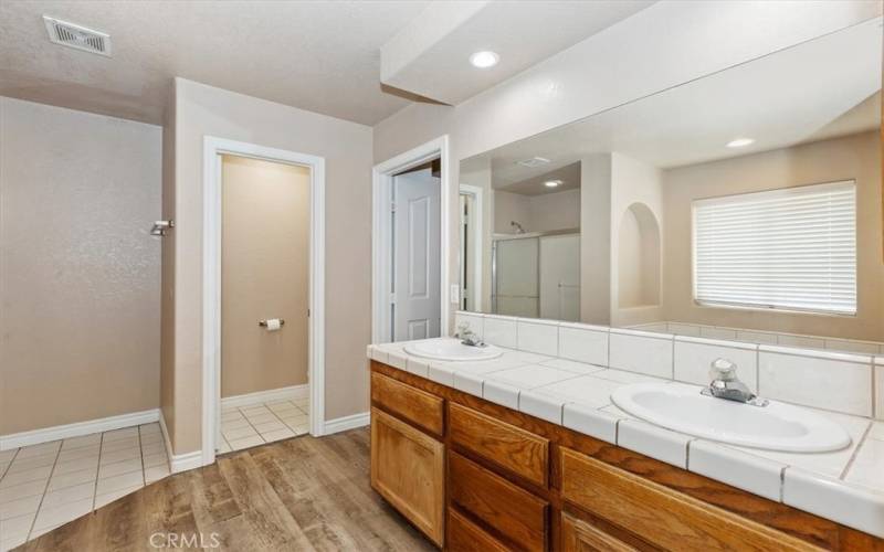 Dual sinks and entrance into the walk-in closet.