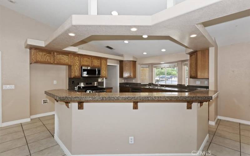 Recessed lighting provides great light. Just through the doorway by the stove is an open pantry. You will love the easy access and the discreet location.