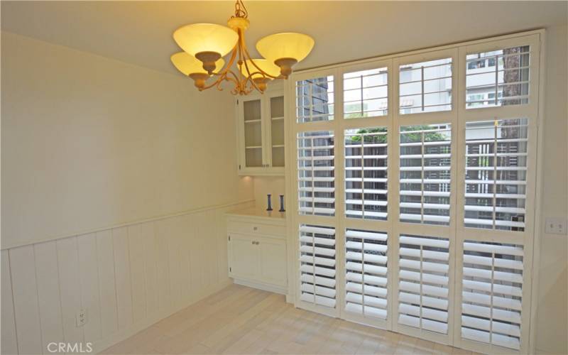 The wood shutters can be folded aside to open the tall glass sliding doors to the patio.